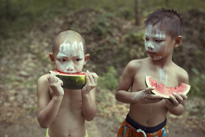 Boys with painted face having watermelon