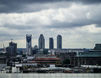 View of cityscape against cloudy sky