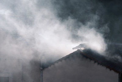 Low angle view of building. fire and smoke on  roof. 