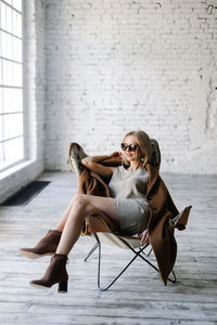 Full length portrait of woman sitting outdoors