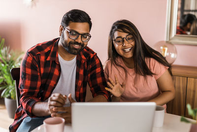 Portrait of young woman using laptop at home