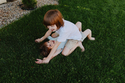 High angle view of boy playing with ball on grassy field