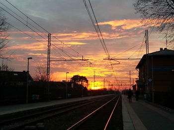 Railroad tracks against sky during sunset