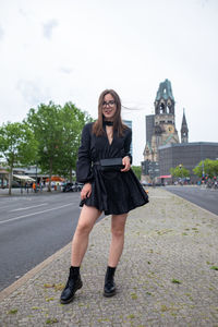 Portrait of smiling young woman standing in city