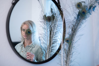 Portrait of woman holding glass window