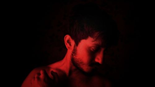 Portrait of young man against black background