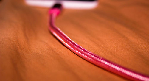 Close-up of red computer cable on table