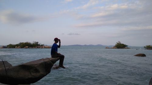 Man in sea against sky