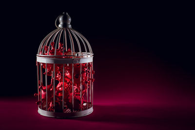 Close-up of illuminated lamp on table against black background