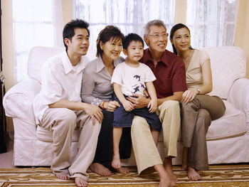Smiling family looking away while sitting at home