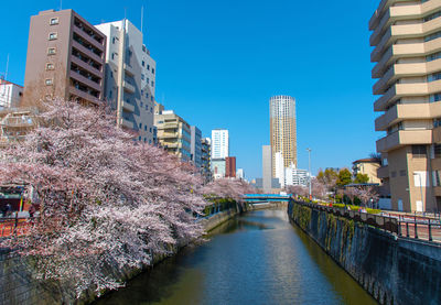 Canal amidst buildings against sky in city