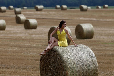 Full length of man with hay bales on field