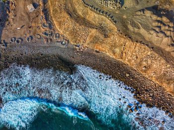 Directly above shot of waves splashing on rocks at beach