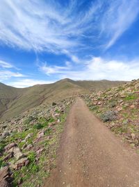 Road leading towards mountain against sky