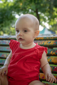 Portrait of cute baby girl sitting outdoors