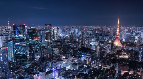 Illuminated cityscape against sky at night