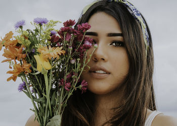 Close-up portrait of beautiful woman against blue sky