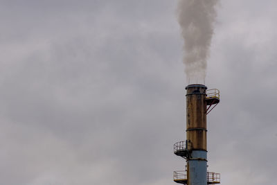 Low angle view of a smoke stack against sky