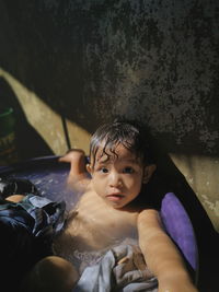 Portrait of cute girl sitting in bathtub