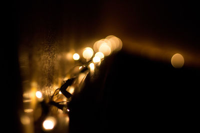 Close-up of illuminated lights against sky at night