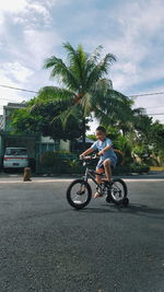 Side view of man riding bicycle on road