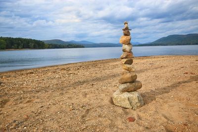 Stack of pebbles on beach against sky