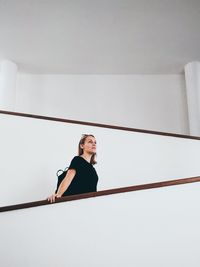 Low angle view of woman standing against wall