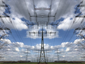 Mirrored low angle view of electricity pylon against sky