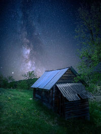 House on field against sky at night