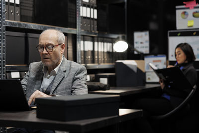 Side view of businessman using laptop at office