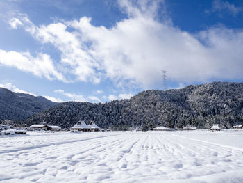 Snow covered landscape against sky