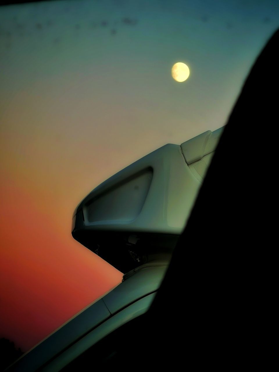 CLOSE-UP OF SILHOUETTE CAR ON WINDOW DURING SUNSET