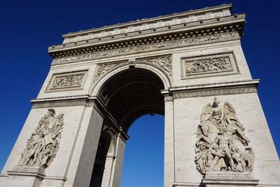 Low angle view of arc de triomphe on sunny day