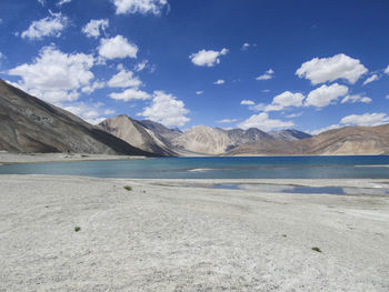 Idyllic shot of lake and mountains against sky