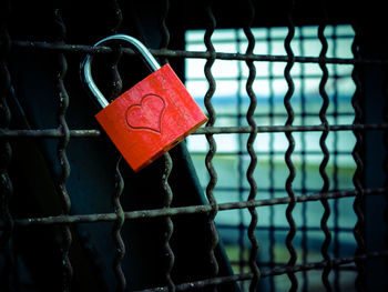 Close-up of red padlock on railing