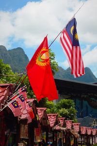 Multi colored flags on mountain against sky