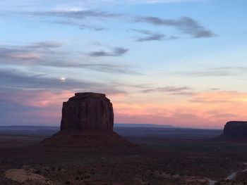 Rock formations on landscape against sky during sunset