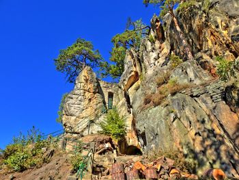 Low angle view of rock formation against clear blue sky