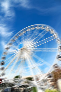 Low angle view of ferris wheel against blue sky