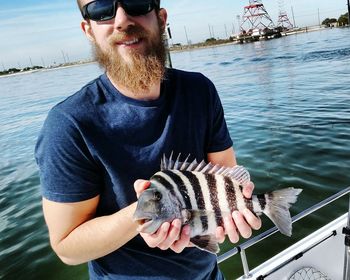 Portrait of man holding fish in sea