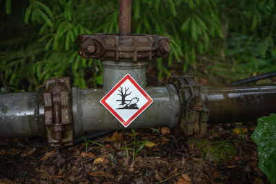 Close-up of warning sign on pipe
