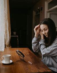 Young woman using mobile phone while sitting at home