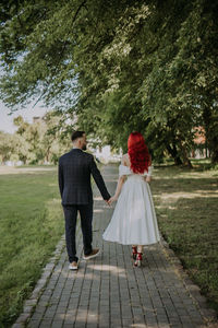 Wedding day. happy bride and groom walking in the park. red