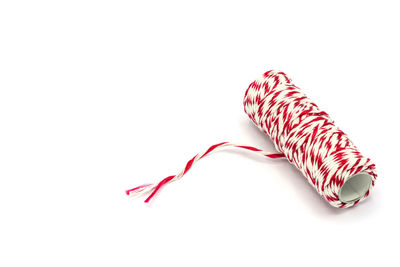 Close-up of pink tied over white background