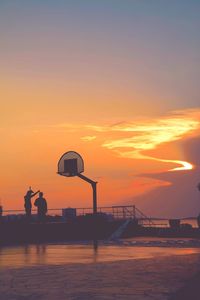 Silhouette of ferris wheel at sunset