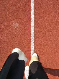 Low section of person standing on tiled floor