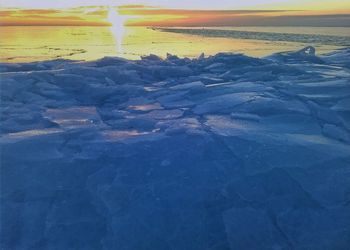 Aerial view of land and sea during sunset