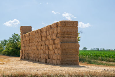 Stone wall on field against sky