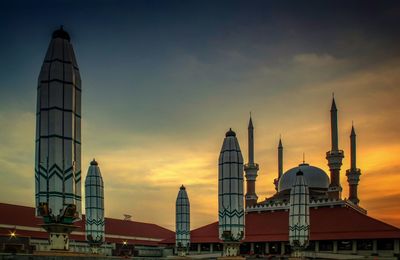 Buildings in city against sky during sunset