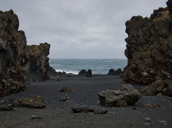 Rocks on beach against sky